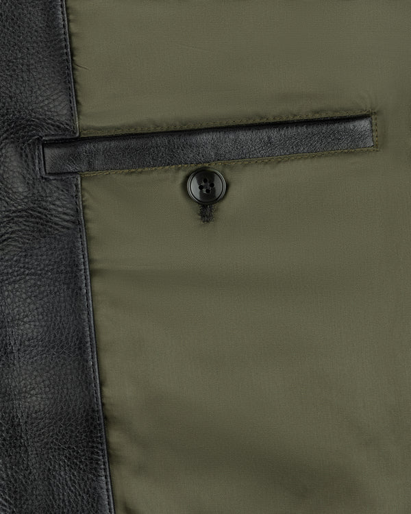 Interior view of a Napa Leather Bomber Jacket featuring a green lining, a leather-trimmed pocket, and a button closure.