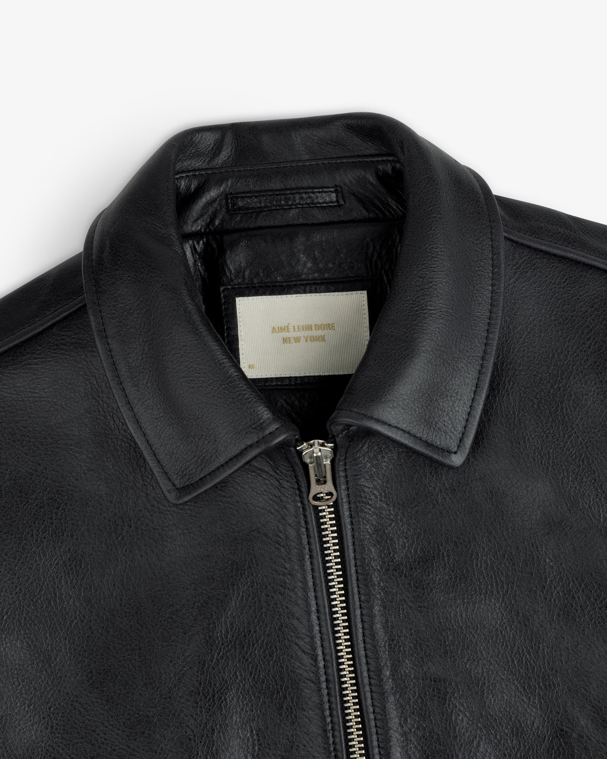 Close-up of a black Napa Leather Bomber Jacket featuring a front zipper and a white interior collar label.