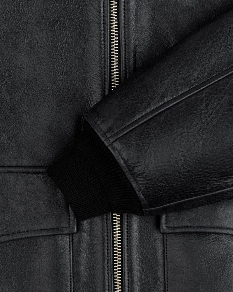 Close-up of a black Napa Leather Bomber Jacket featuring a metal zipper and a ribbed knit cuff.