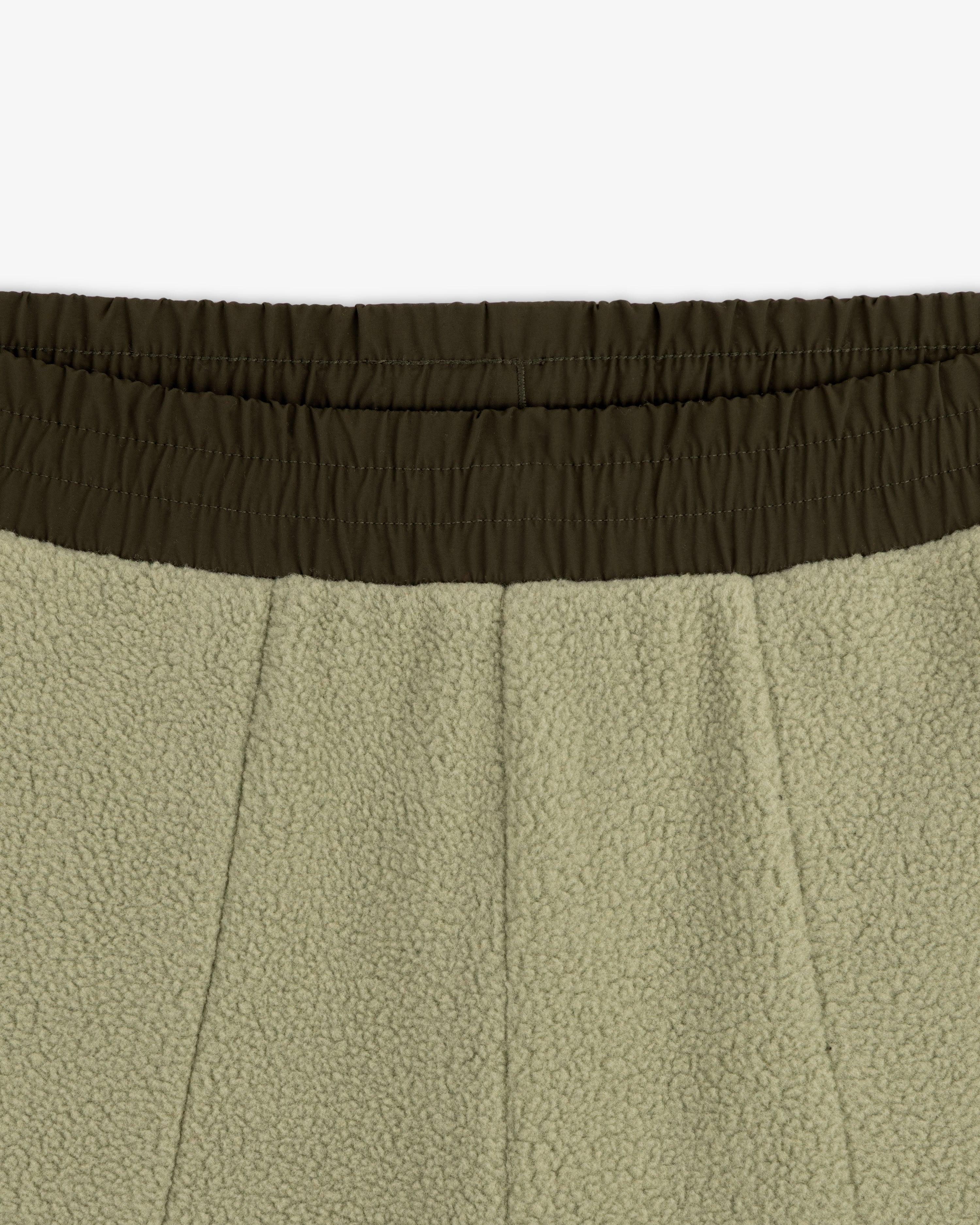 Close-up of the elastic waistband and upper section of olive green ALD / The North Face Denali Fleece Pant.