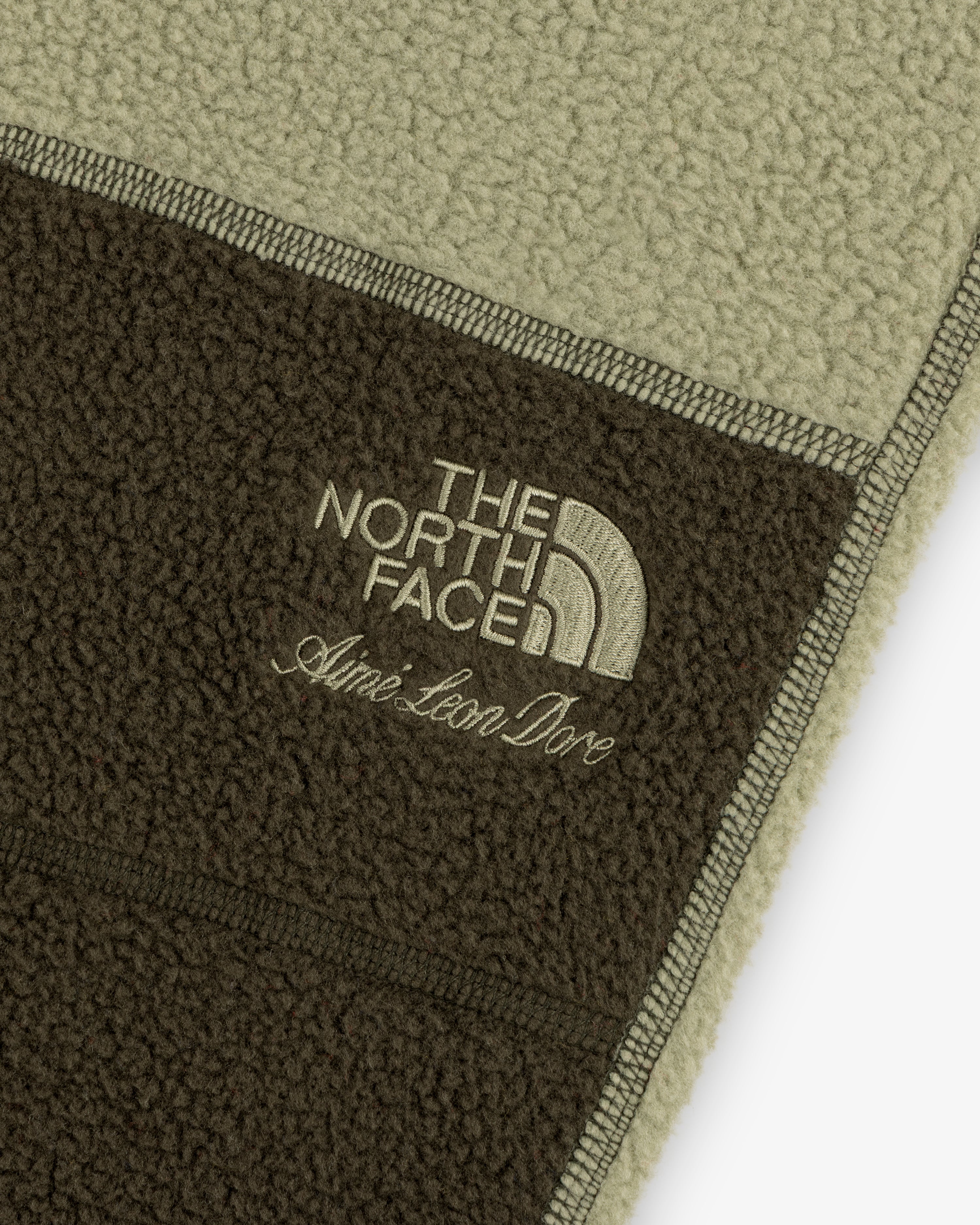Detail of ALD / The North Face Denali Fleece Pant with beige embroidered logos on two-tone fleece fabric.