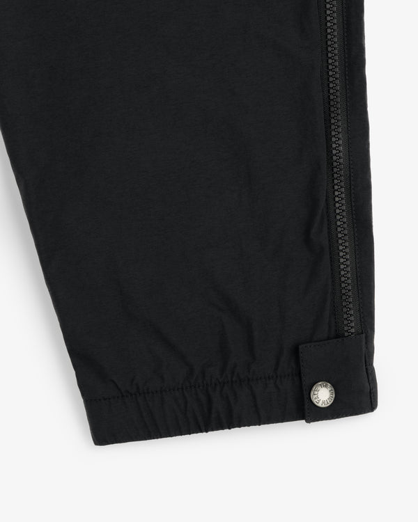 Close-up of ALD / The North Face Nylon Denali Pant showing a black pant leg with zipper and silver snap at the cuff.