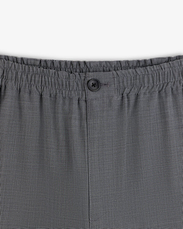 Close-up of the waistband on the Houndstooth Elasticated Waist Trouser with an elastic band and black button detail.