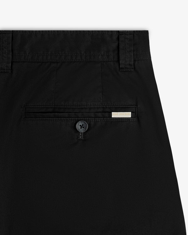 Close-up of the back pocket on Double Pleated Officer Pant, featuring a button and a small rectangular tag above it.