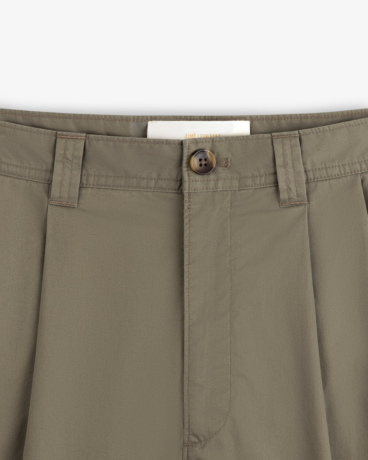 Close-up of Double Pleated Officer Pant in olive green, showing waistband, belt loops, button closure, and inside label.
