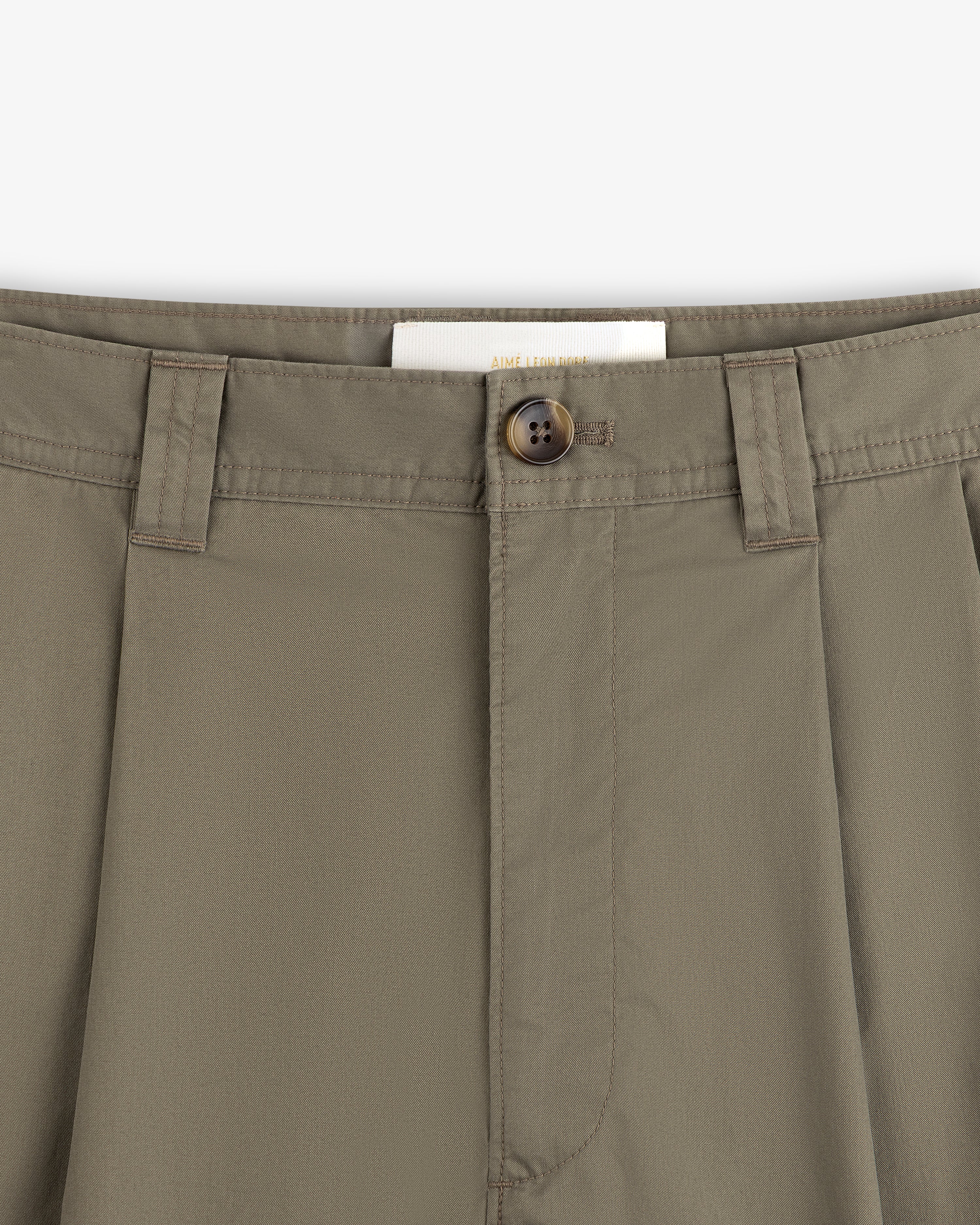 Close-up of Double Pleated Officer Pant in olive green, showing waistband, belt loops, button closure, and inside label.