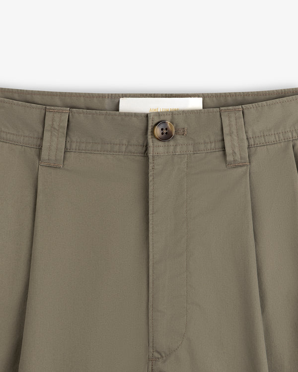 Close-up of Double Pleated Officer Pant in olive green, showing waistband, belt loops, button closure, and inside label.
