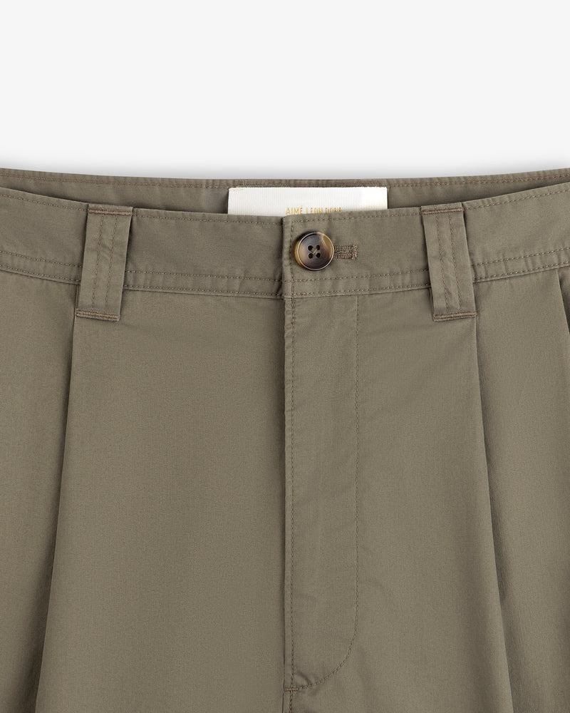 Close-up of Double Pleated Officer Pant in olive green, showing waistband, belt loops, button closure, and inside label.