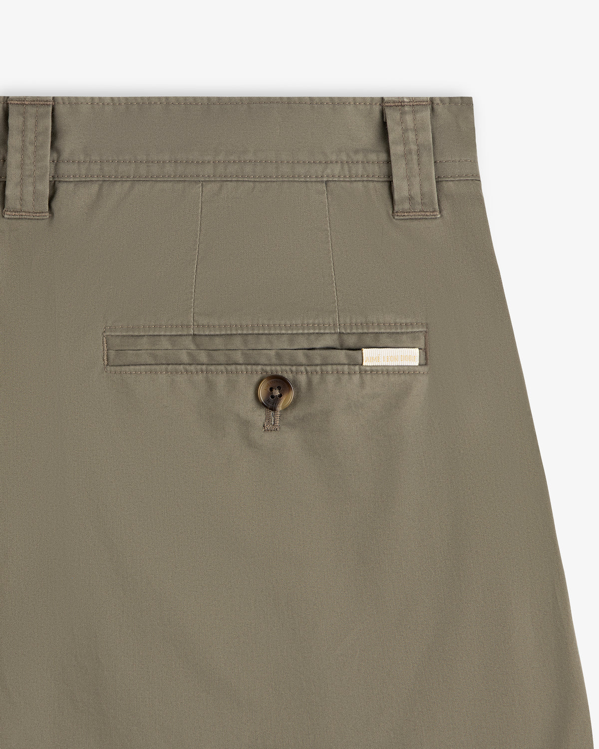Close-up of Double Pleated Officer Pant in khaki with button pocket, belt loops, and a rectangular brand label above.