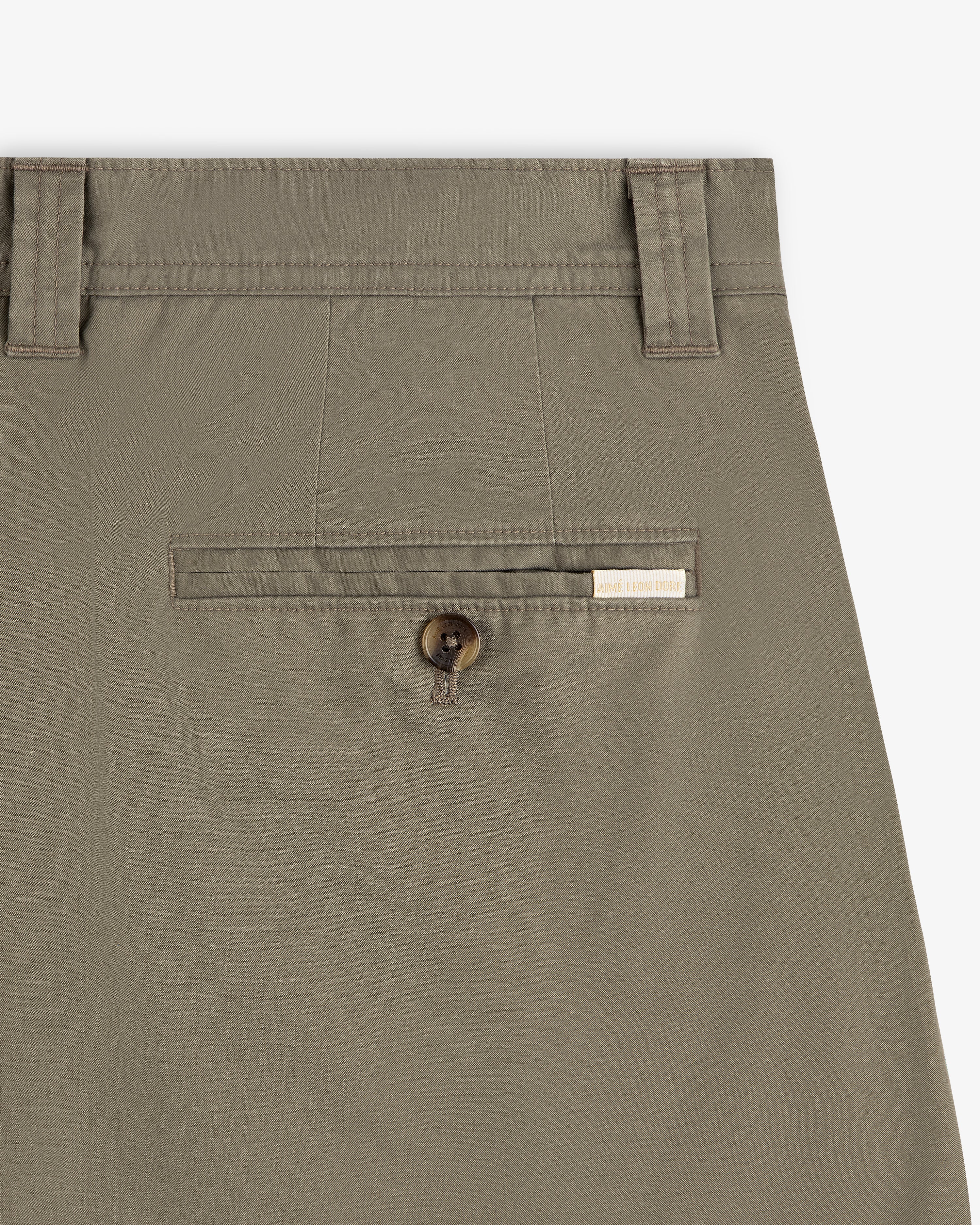 Close-up of Double Pleated Officer Pant in khaki with button pocket, belt loops, and a rectangular brand label above.