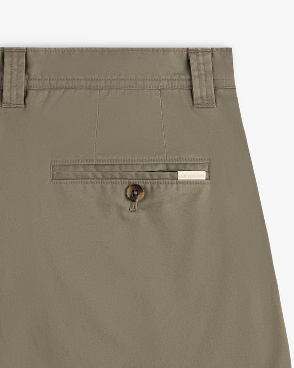 Close-up of Double Pleated Officer Pant in khaki with button pocket, belt loops, and a rectangular brand label above.