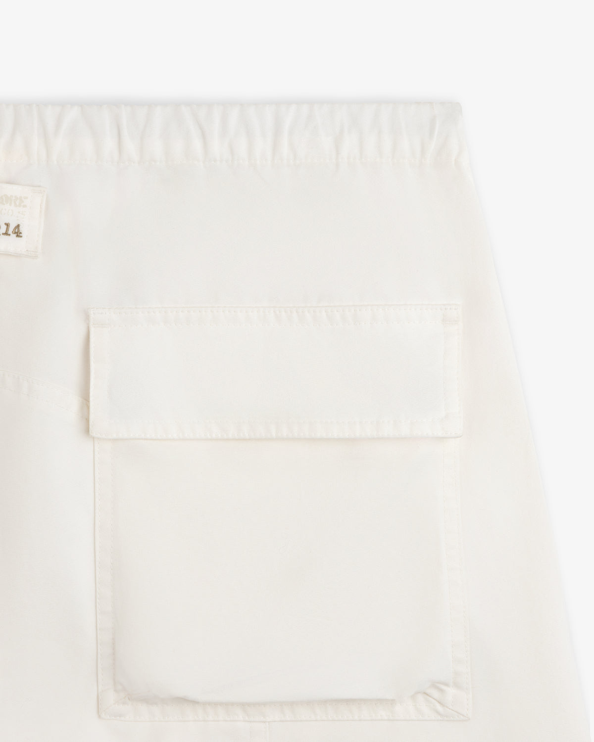 Garment Washed Aviator Pants in off-white with an elastic waistband and a large patch pocket on the leg.