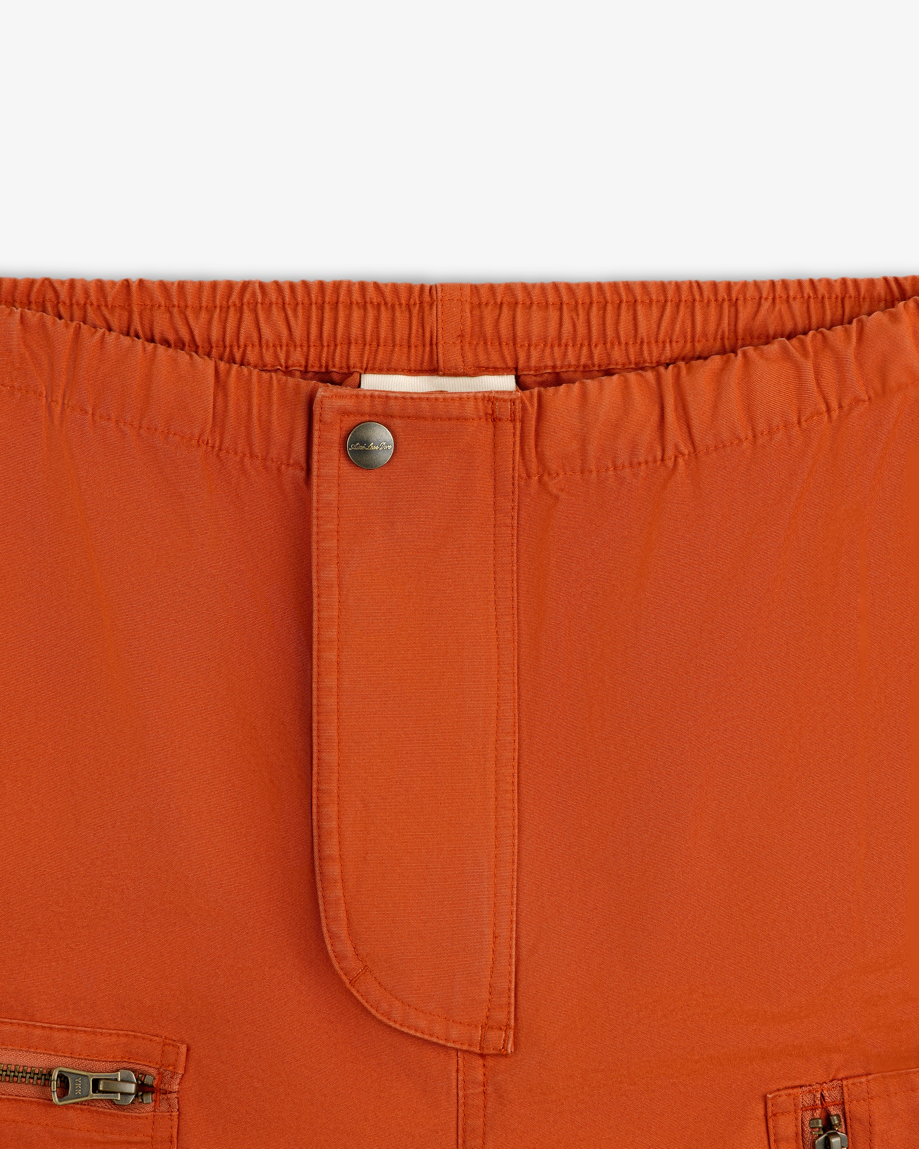 Garment Washed Aviator Pants in rust with an elastic waistband, a single metal button, and front zipper pockets.
