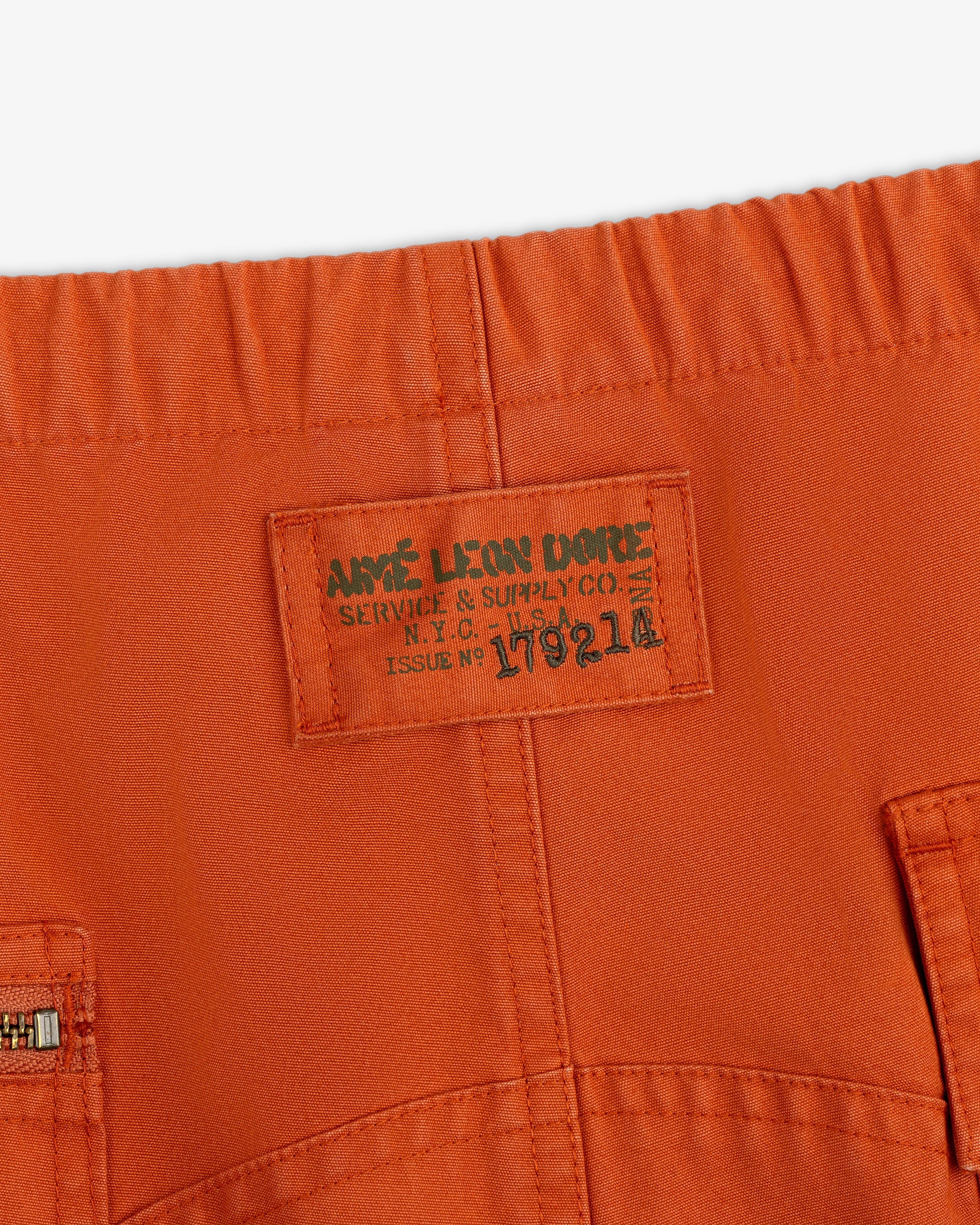 Garment Washed Aviator Pants in orange with an elastic waistband and a rectangular Aime Leon Dore label.