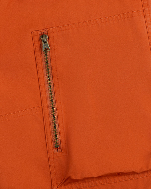 Close-up of a vertical zipper pocket on the orange Garment Washed Aviator Pant.