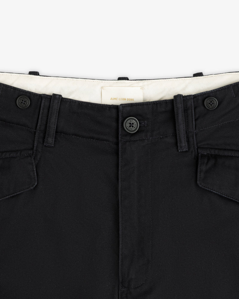 Close-up of the Fatigue Pant’s black waistband with two buttons, belt loops, and flap pockets on white background.