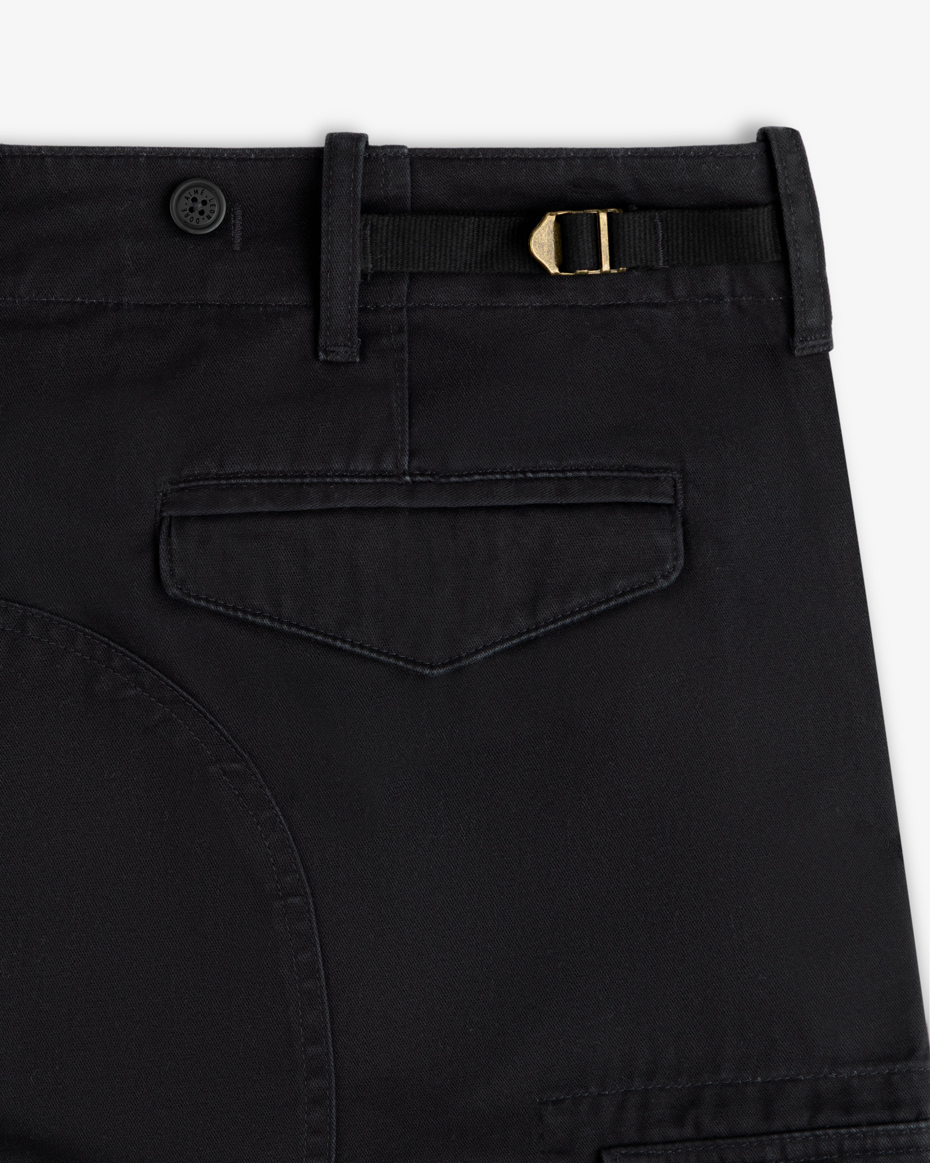 Close-up of Fatigue Pant: black with belt loop, button, gold buckle strap, and flap back pocket.