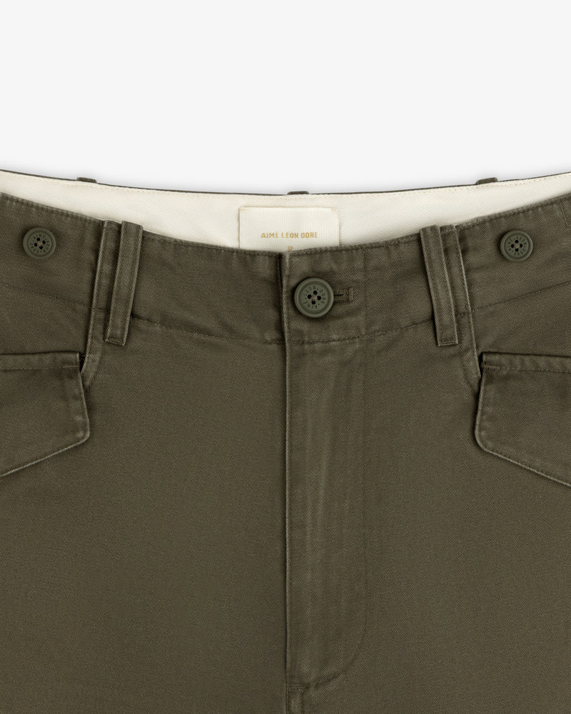 Close-up of Fatigue Pant in olive green, featuring button closure, front pockets, and a white waistband label.