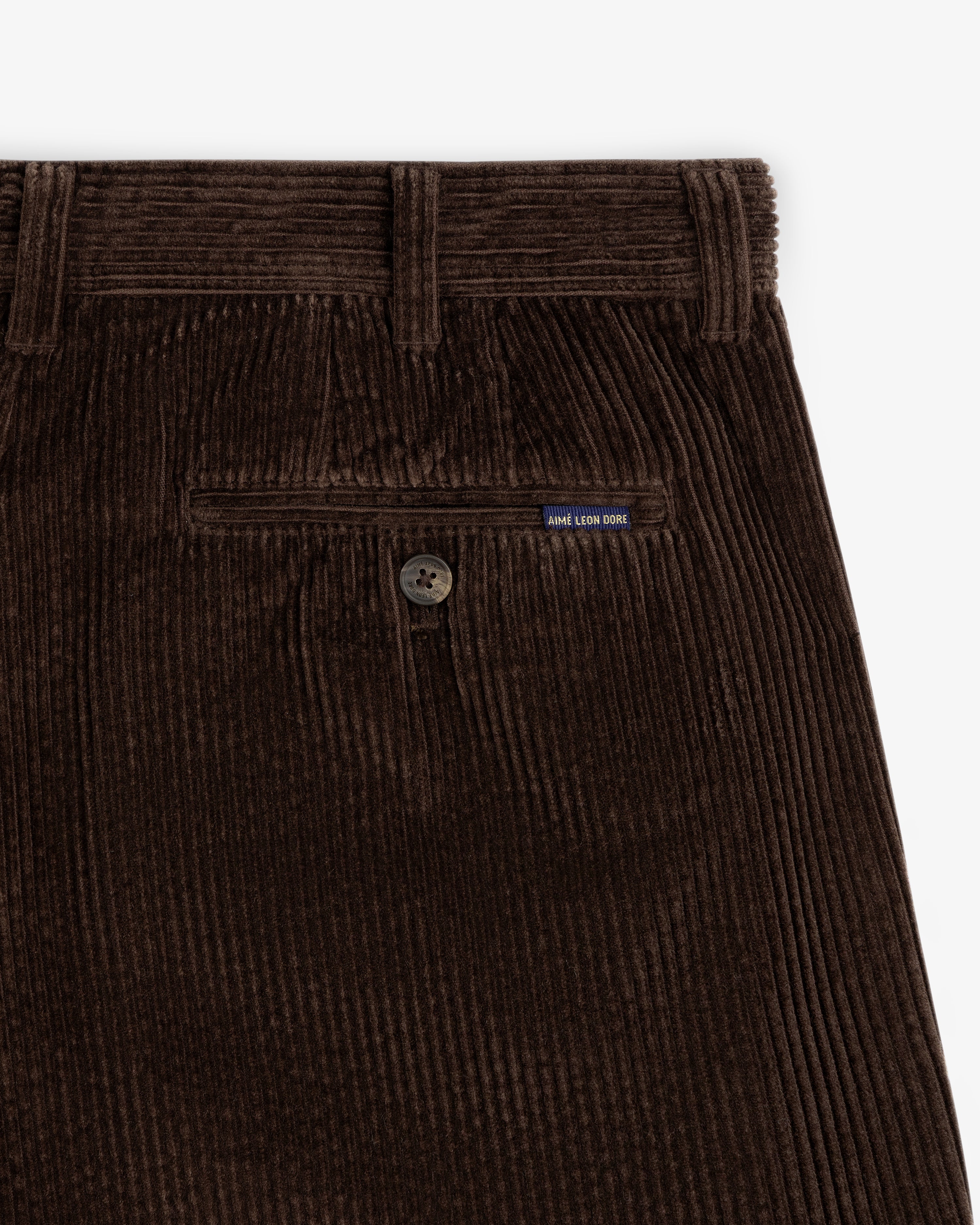 Dark brown Corduroy Trouser featuring a buttoned back pocket with a small brand tag.