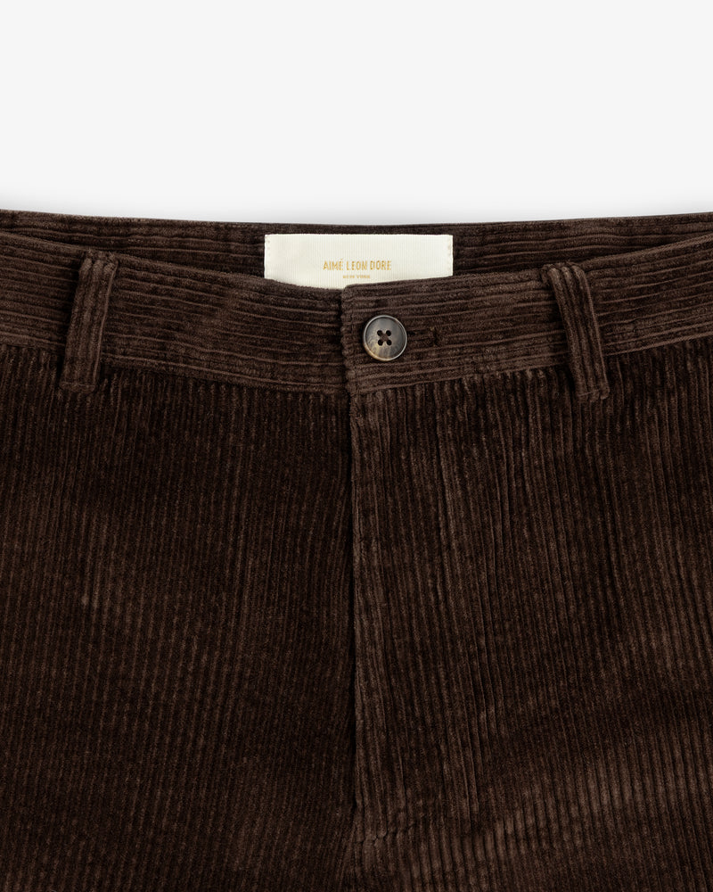 Close-up of brown Corduroy Trouser featuring a button closure and a brand label at the waistband.