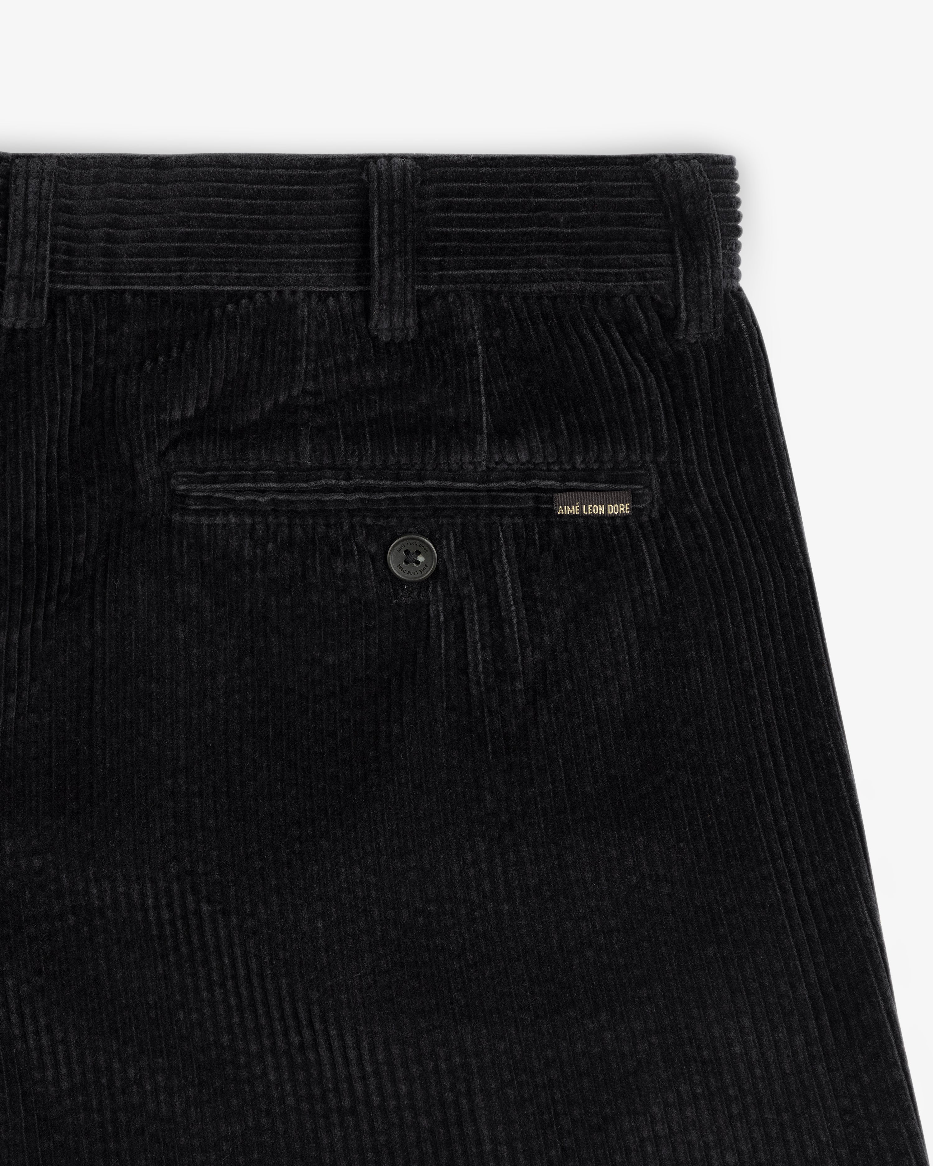 Black Corduroy Trouser featuring a buttoned back pocket with a small branded tab.