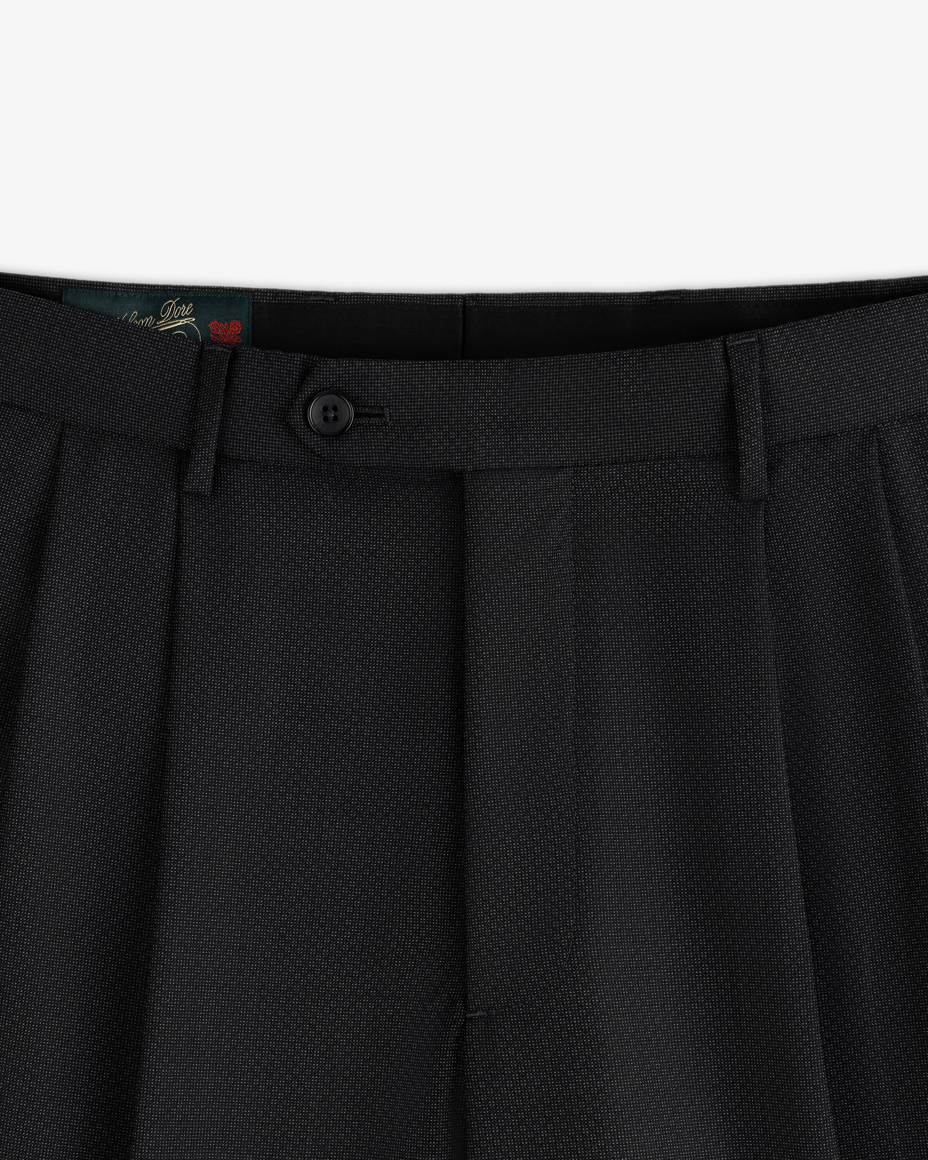 Close-up of the waistband and button closure of black Double Pleated Wool Jacquard Suit Trouser.