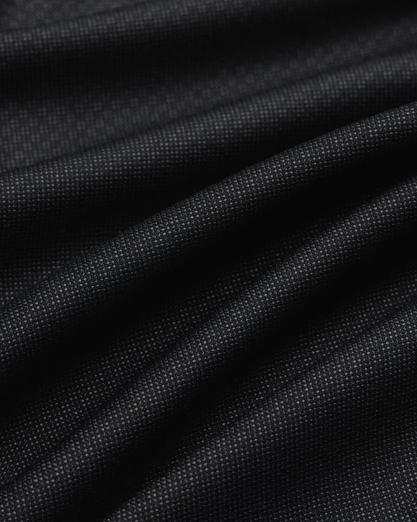 Close-up of draped black fabric with a fine textured weave for Double Pleated Wool Jacquard Suit Trouser.