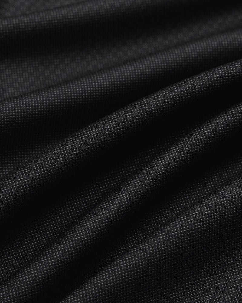 Close-up of draped black fabric with a fine textured weave for Double Pleated Wool Jacquard Suit Trouser.