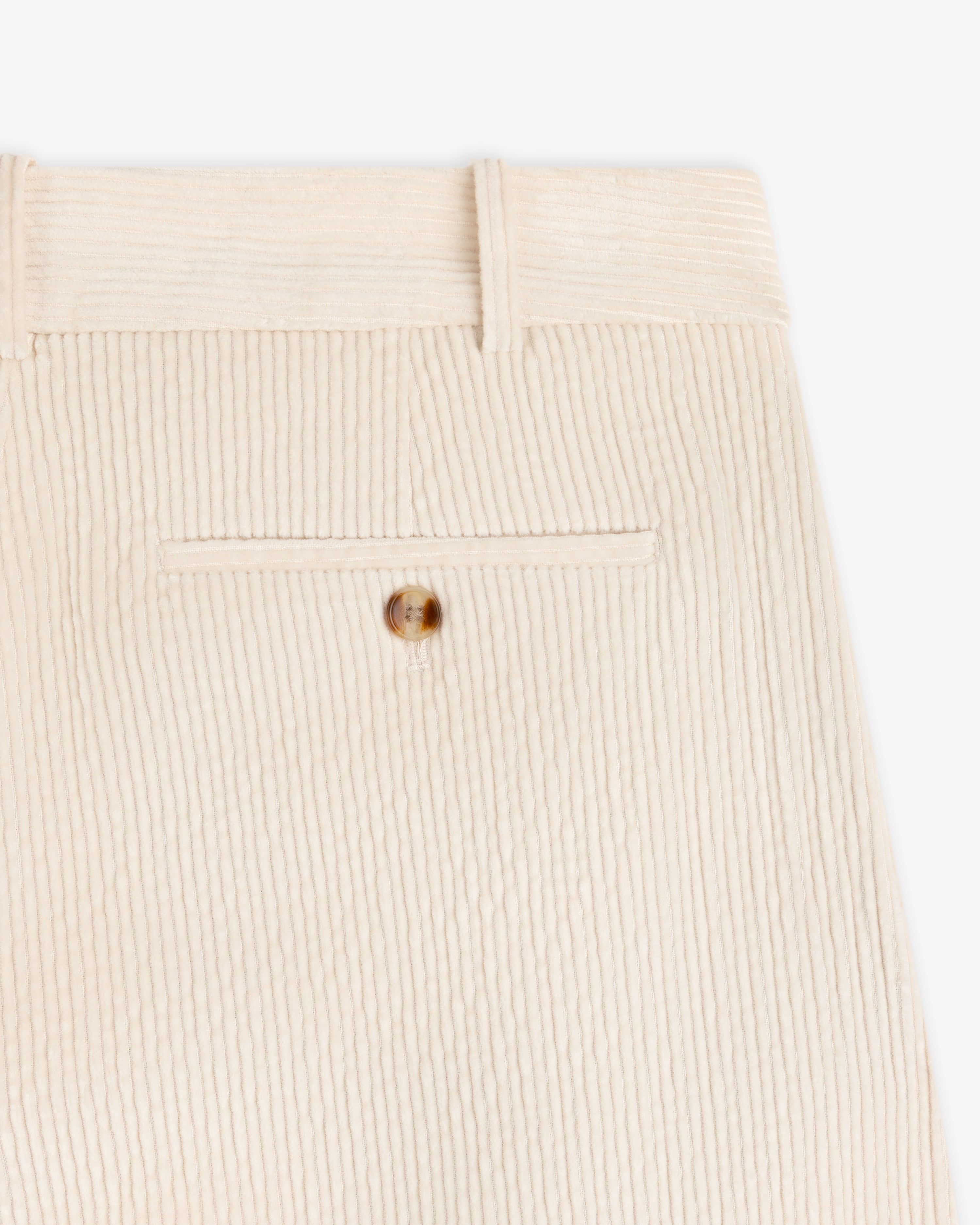 Close-up of cream-colored Double Pleated Corduroy Trouser featuring a back pocket with a button closure and belt loops.