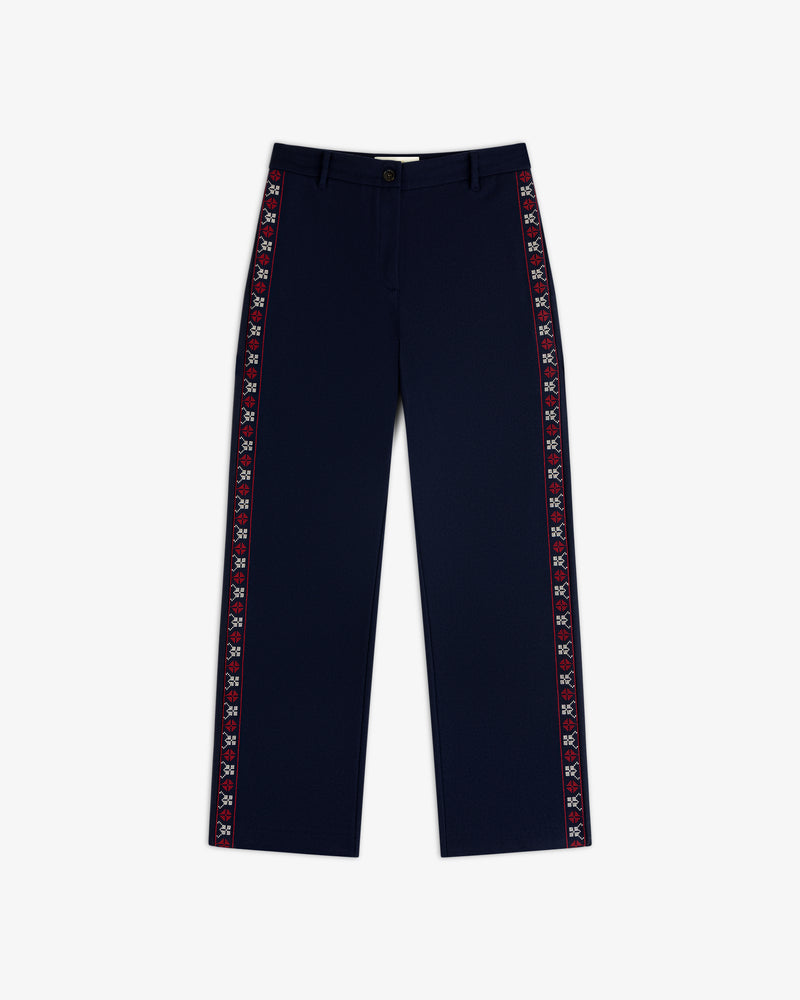 Mani Embroidered Wool Pant in navy blue with a decorative red and white embroidered stripe down each side.