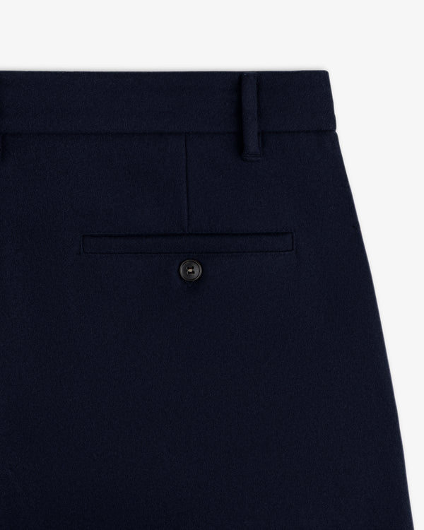 Close-up of the Mani Embroidered Wool Pant back pocket in dark navy wool with a single button closure.