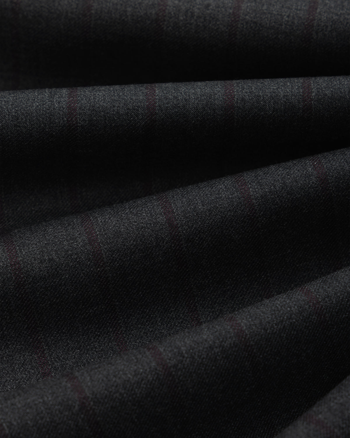 Close-up of dark grey Striped Double Pleated Suiting Trouser fabric, featuring subtle vertical pinstripes in ripples.