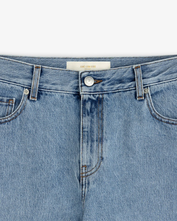 Close-up of ALD Relaxed Fit Denim light-wash blue jeans featuring a button fly and a branded waistband label.