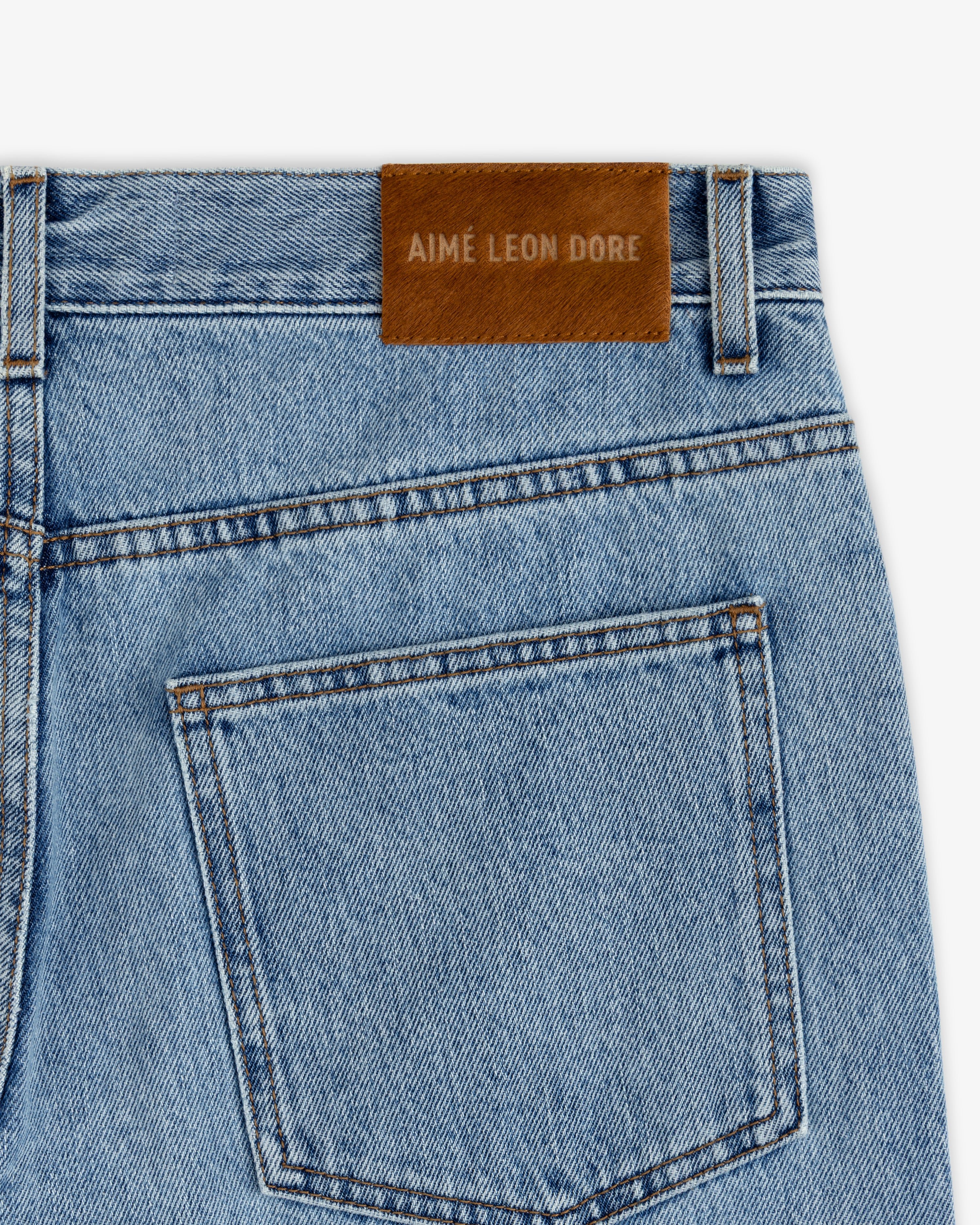 Back view of ALD Relaxed Fit Denim in light-wash with a brown leather patch on the waistband.