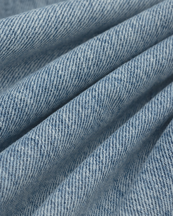 Close-up of light blue ALD Relaxed Fit Denim fabric with diagonal folds.