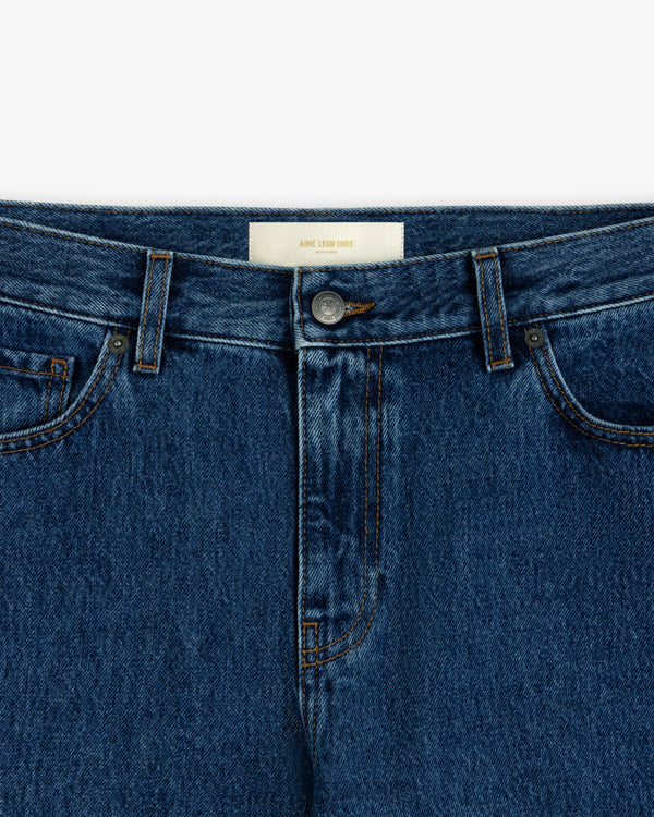 Close-up of the waistband and button fly of blue ALD Relaxed Fit Denim jeans with a cream-colored interior label.