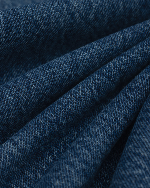 Close-up of folds in the dark blue denim fabric of the ALD Relaxed Fit Denim.