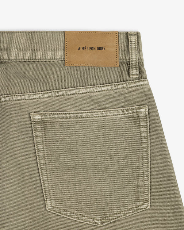 Flocked Straight Fit Denim jeans in olive green with a back pocket and tan brand-labeled leather patch.