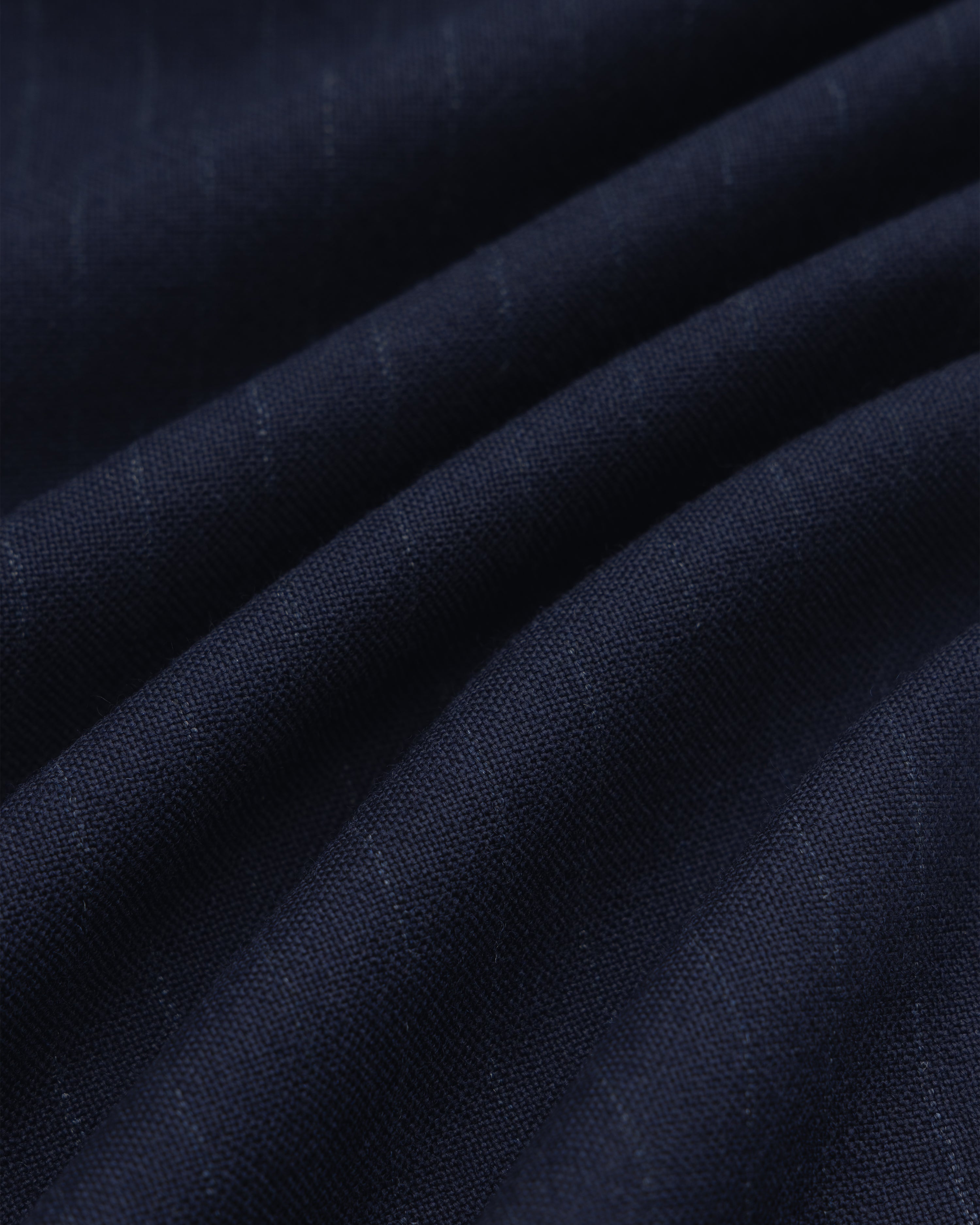 Dark blue Wool Chalk Stripe Elasticated Waist Trouser fabric with subtle vertical chalk stripes, shown in soft folds.