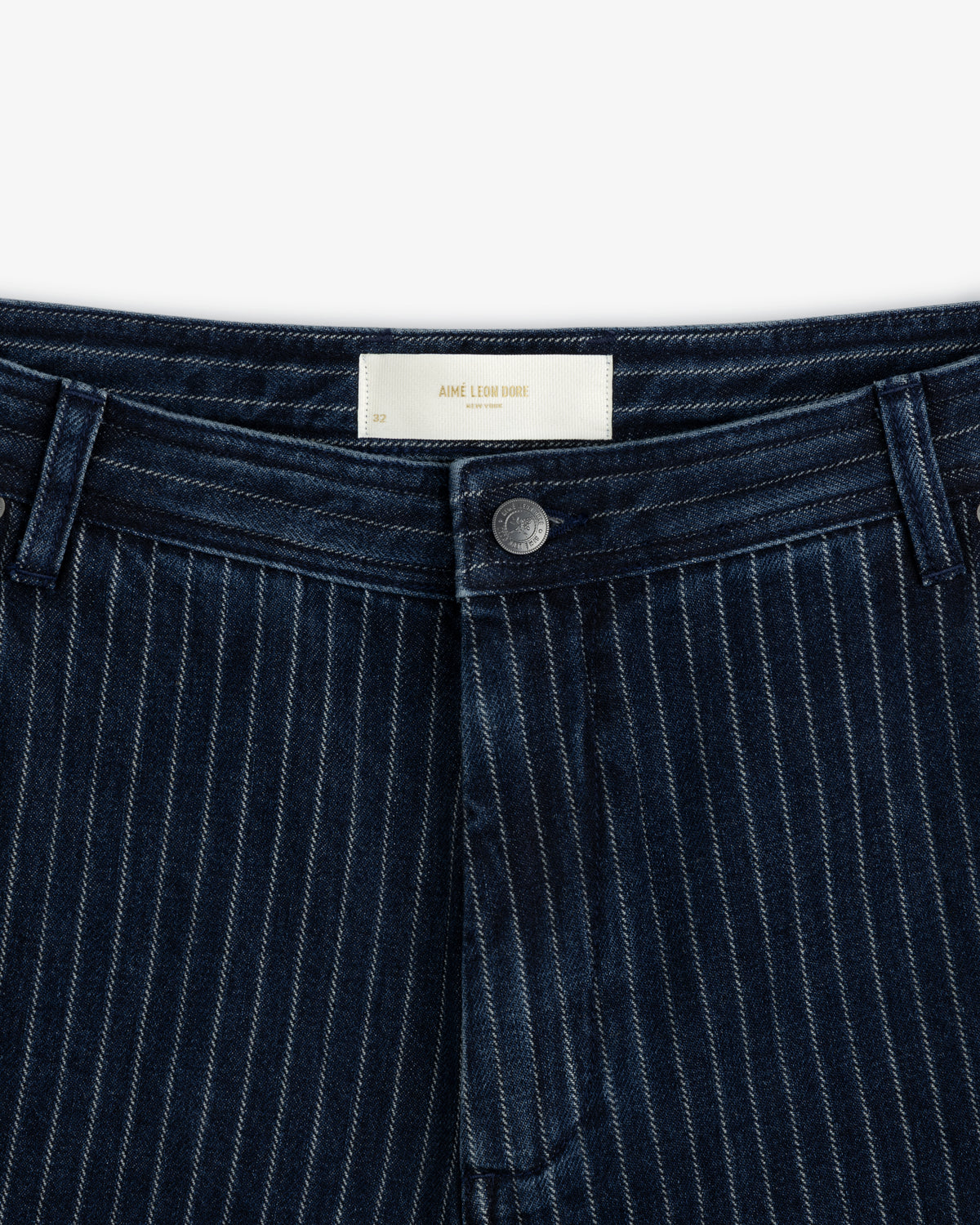 Close-up of Chalk Stripe Painter Pant in dark blue with a button, belt loops, and a white waistband label.