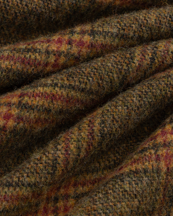 Close-up of brown, green, and red Plaid Tweed Suit Trouser fabric folded into ridges.