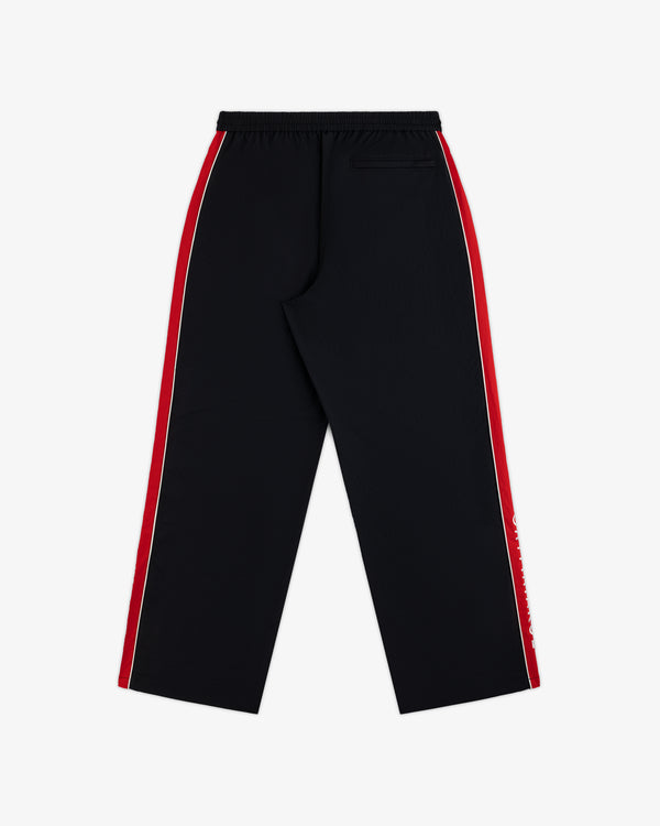 Back view of ALD / Olympiacos F.C. Nylon Track Pant in black with red and white side stripes and a single back pocket.