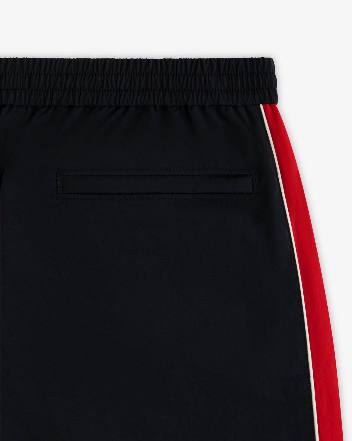 ALD / Olympiacos F.C. Nylon Track Pant in black with an elastic waistband, back pocket, and red and white side stripe.