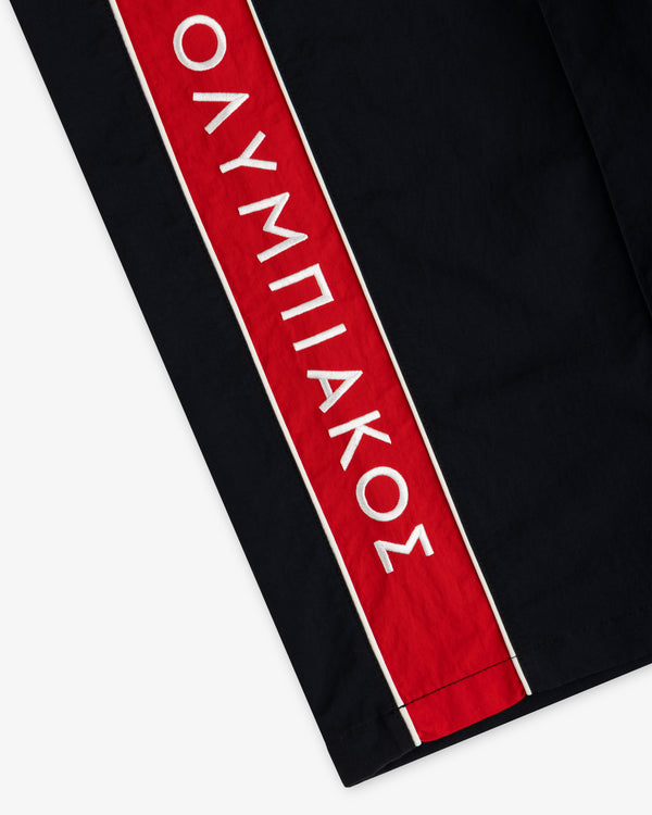 ALD / Olympiacos F.C. Nylon Track Pant in black with a vertical red stripe featuring white Greek text.