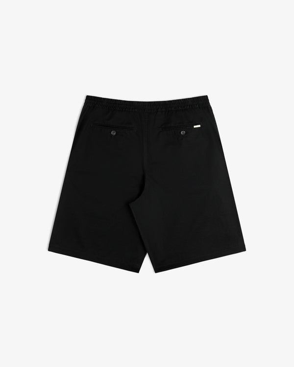 Cotton Casual Short in black, back view with two buttoned pockets and a white tag above the right pocket.