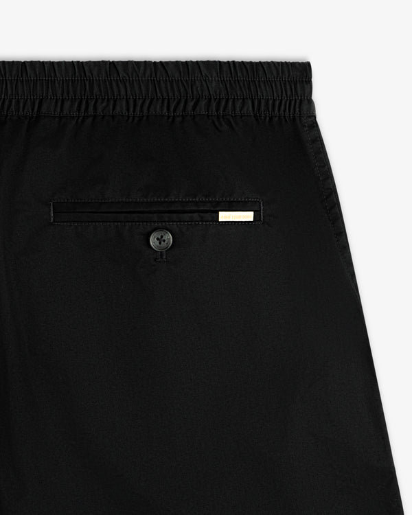 Close-up of Cotton Casual Short in black with elastic waistband, back pocket, button, and small metal label.
