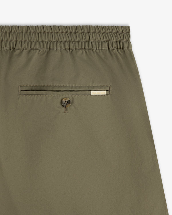 Close-up of Cotton Casual Short in olive green with elastic waist, back button pocket, and small label.