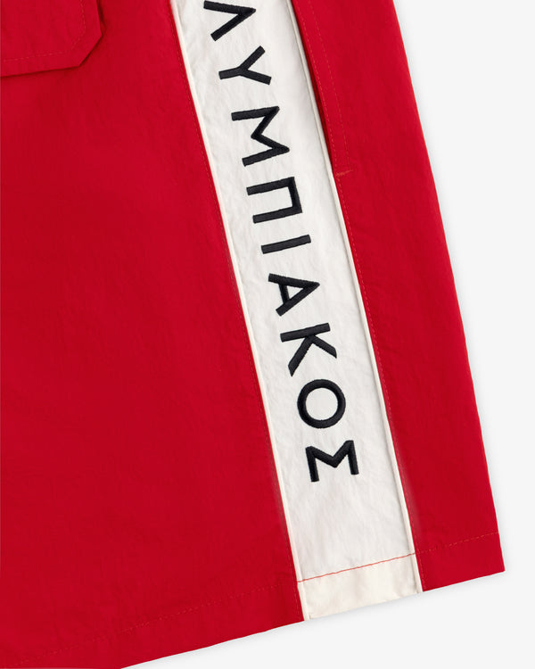 ALD / Olympiacos F.C. Nylon Training Short: red nylon shorts with a white side stripe featuring black Greek lettering.