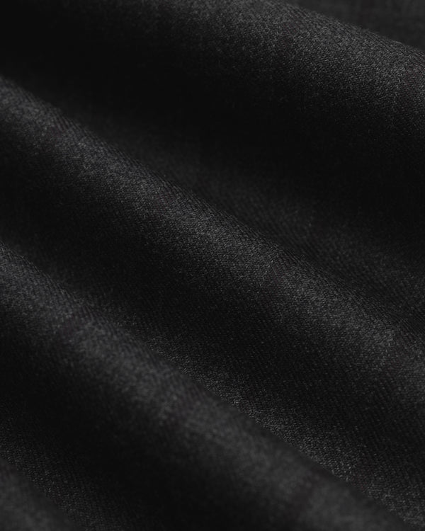 Close-up of black fabric with subtle vertical pinstripes and soft folds on a Striped Tailored Maxi Skirt.