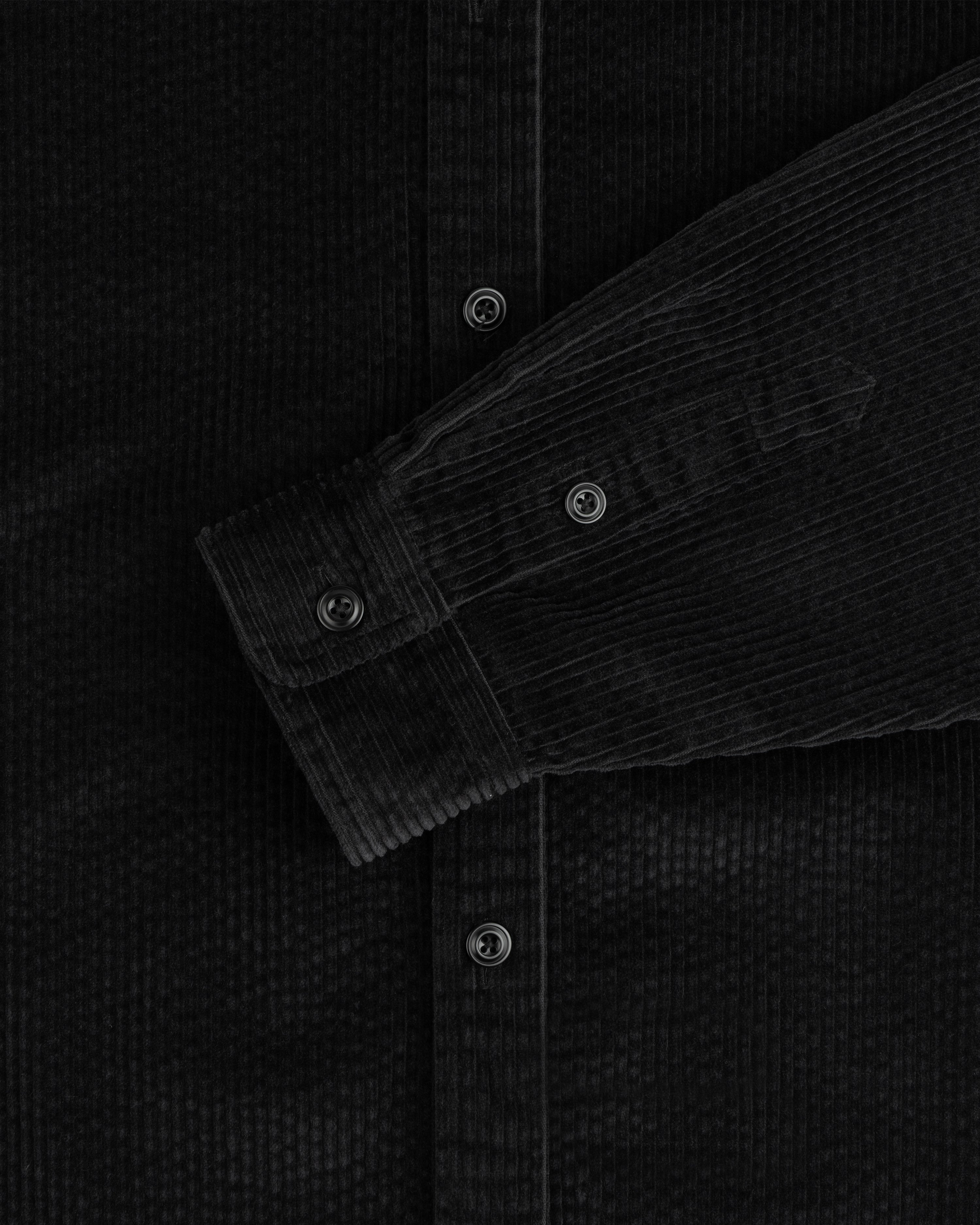 Black Corduroy Leon Overshirt with a buttoned sleeve cuff and front placket.